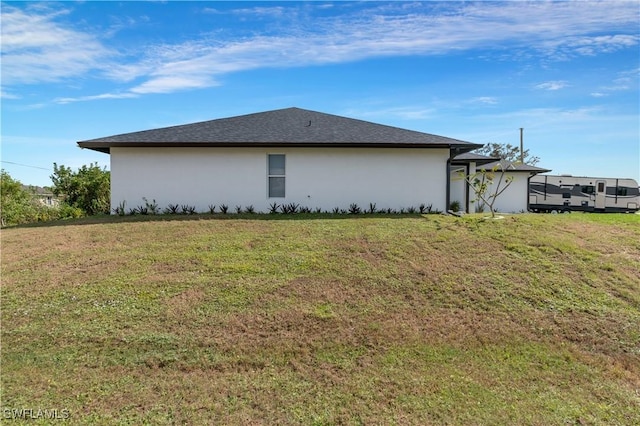 2918 12th St SW, Lehigh Acres, FL 33976 - view of side of home featuring stucco siding and a yard