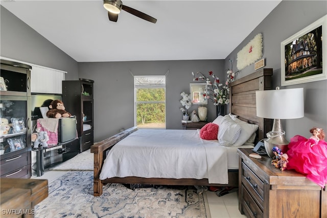 bedroom featuring light tile patterned floors, vaulted ceiling, and ceiling fan