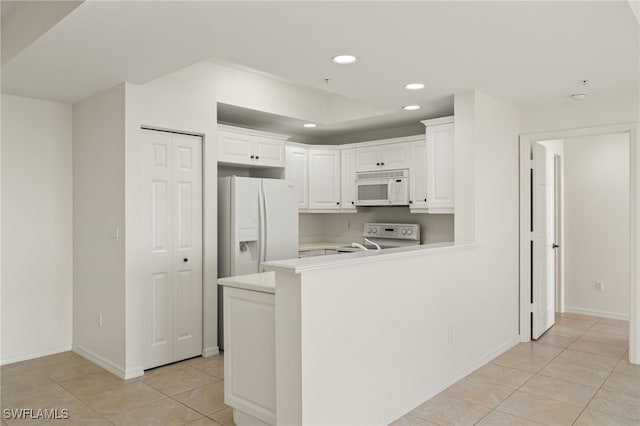 kitchen featuring white appliances, kitchen peninsula, white cabinets, and light tile patterned flooring