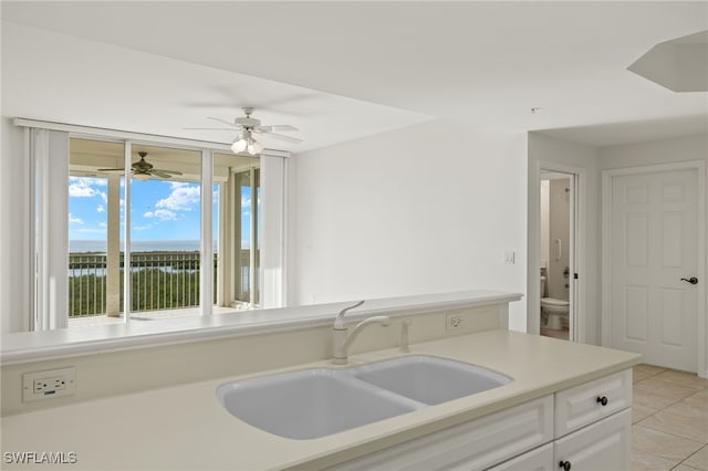 1001 Arbor Lake Dr Unit 1003, Naples, FL 34110 - kitchen featuring a sink, light tile patterned floors, white cabinetry, light countertops, and a ceiling fan