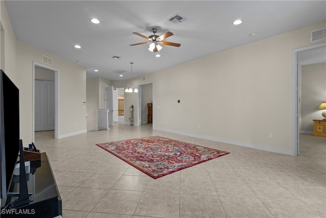 tiled living room with ceiling fan with notable chandelier