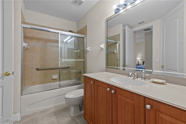 full bathroom with tile patterned floors, vanity, combined bath / shower with glass door, and toilet