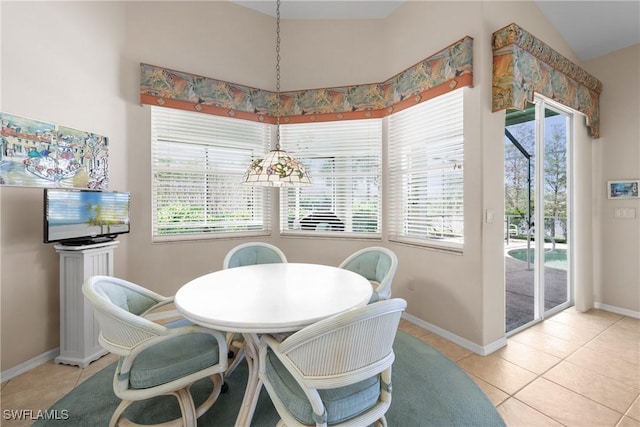 dining space with light tile patterned floors, vaulted ceiling, and plenty of natural light