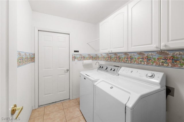 clothes washing area with light tile patterned flooring, cabinets, and independent washer and dryer