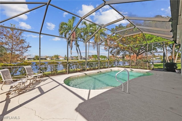 view of swimming pool with glass enclosure, a patio area, and a water view