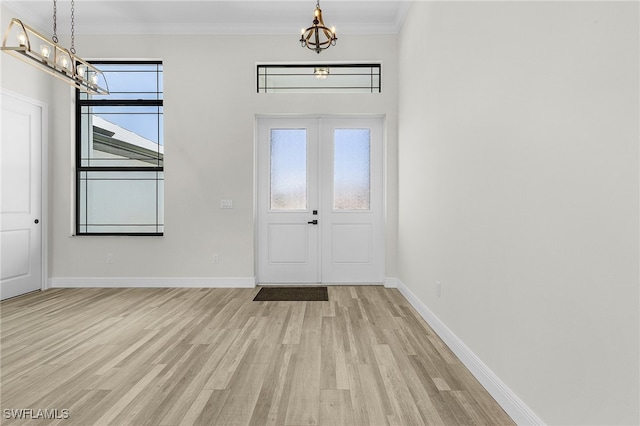 foyer with ornamental molding and light wood-type flooring