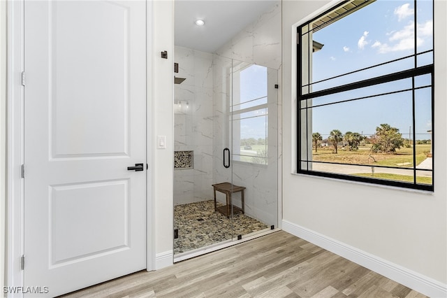 bathroom featuring a shower with shower door and wood-type flooring