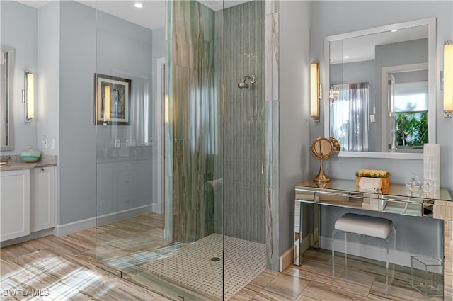 bathroom with vanity and a shower with door