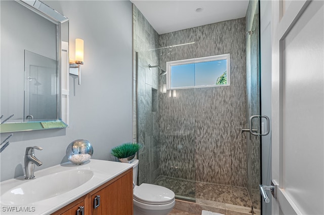 bathroom with toilet, a shower with door, and vanity