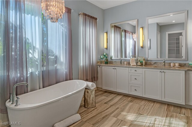 bathroom featuring a tub to relax in, vanity, and a chandelier