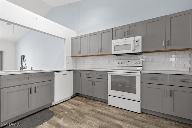 kitchen with white appliances, sink, and gray cabinetry