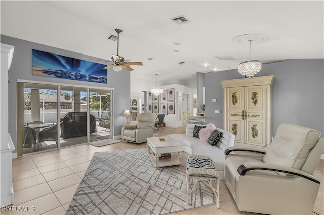 tiled living room with ceiling fan with notable chandelier and vaulted ceiling