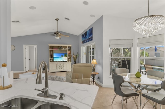 kitchen with sink, decorative light fixtures, vaulted ceiling, light tile patterned floors, and ceiling fan with notable chandelier