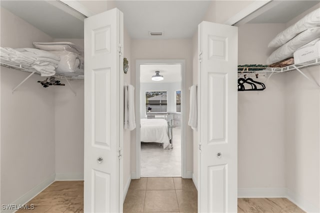 walk in closet with light tile patterned floors