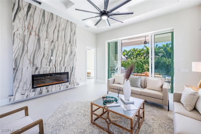 living room with ceiling fan and a high end fireplace