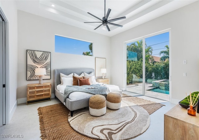 bedroom featuring access to outside, ceiling fan, and a tray ceiling