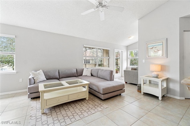 tiled living room featuring lofted ceiling, a textured ceiling, and ceiling fan