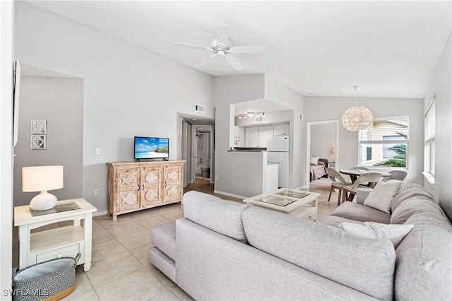 tiled living room featuring ceiling fan and vaulted ceiling