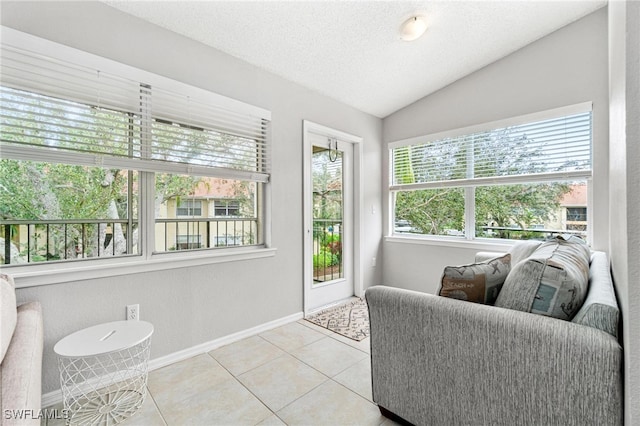 doorway to outside with lofted ceiling, a textured ceiling, and light tile patterned flooring