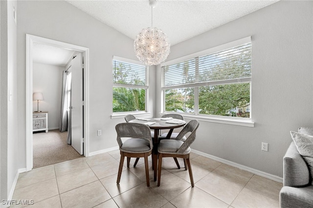 dining area featuring light tile patterned flooring, a textured ceiling, a wealth of natural light, and an inviting chandelier