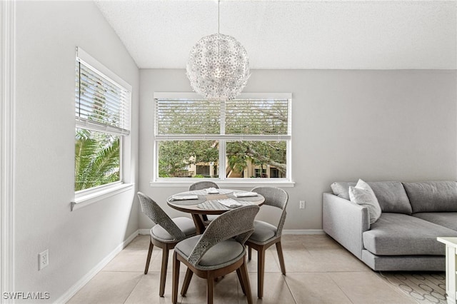 tiled dining area featuring a notable chandelier, a textured ceiling, and vaulted ceiling