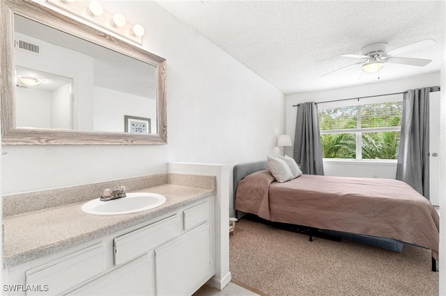 carpeted bedroom featuring sink, a textured ceiling, and ceiling fan