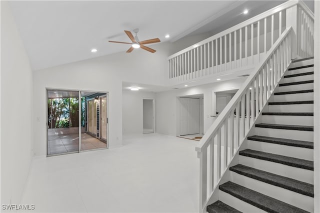 stairs with high vaulted ceiling and ceiling fan