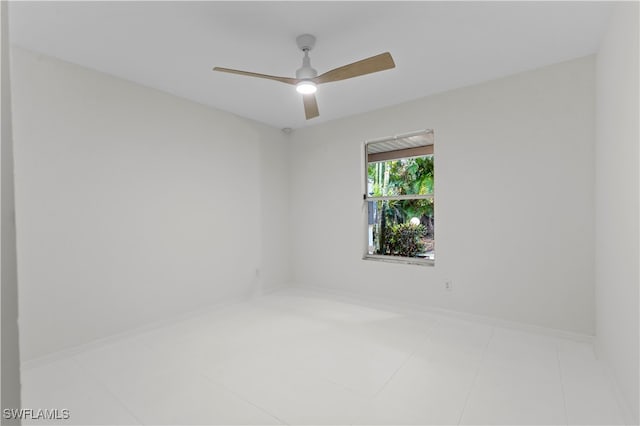 tiled spare room with ceiling fan