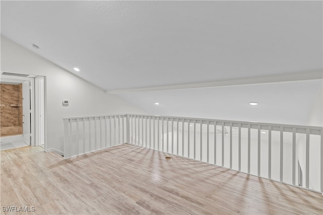 bonus room featuring light hardwood / wood-style floors and vaulted ceiling with beams