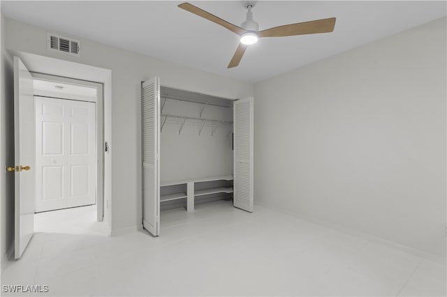 unfurnished bedroom with light tile patterned floors, ceiling fan, and a closet