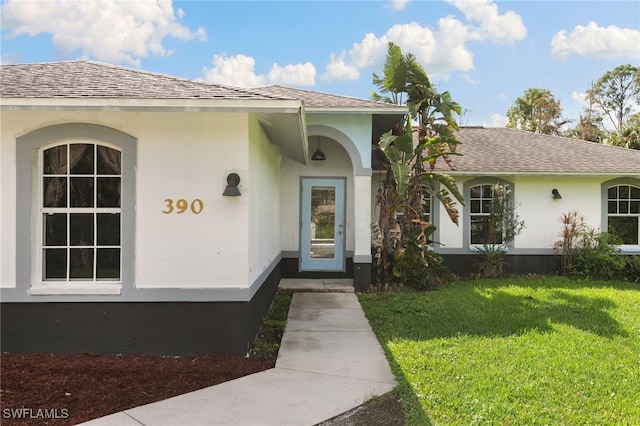 property entrance with a lawn