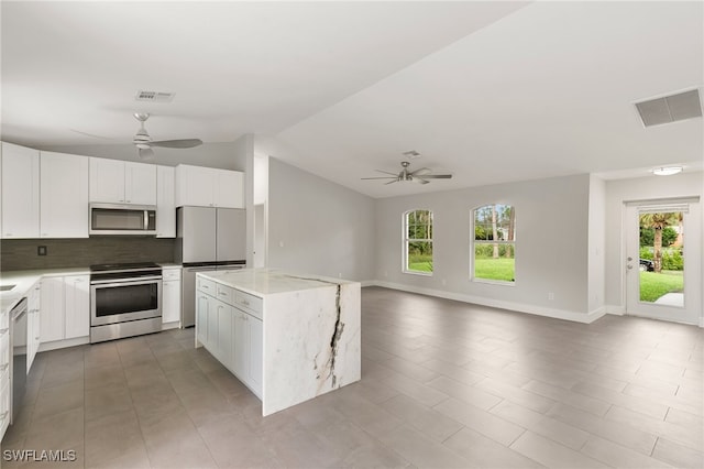 kitchen featuring white cabinetry, stainless steel appliances, ceiling fan, and a kitchen island