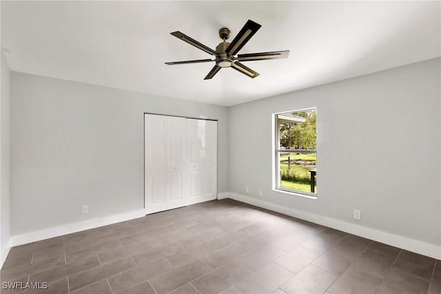 unfurnished bedroom featuring ceiling fan and a closet