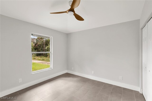 tiled spare room featuring ceiling fan