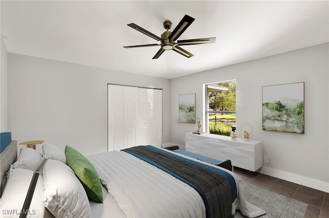 tiled bedroom with ceiling fan and a closet