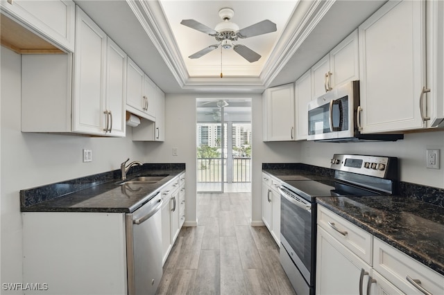 8401 Estero Blvd Unit 204, Fort Myers Beach, FL 33931 - kitchen featuring appliances with stainless steel finishes, a ceiling fan, a raised ceiling, light wood-style floors, and white cabinetry