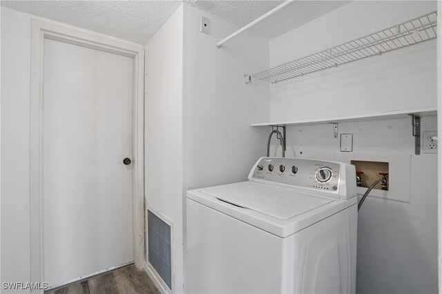 8401 Estero Blvd Unit 204, Fort Myers Beach, FL 33931 - washroom with washer / clothes dryer, dark wood-style flooring, and a textured ceiling