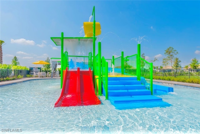 view of playground with pool water feature and a community pool