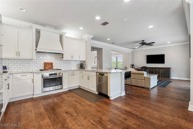 kitchen featuring white cabinetry, custom range hood, stainless steel appliances, and kitchen peninsula