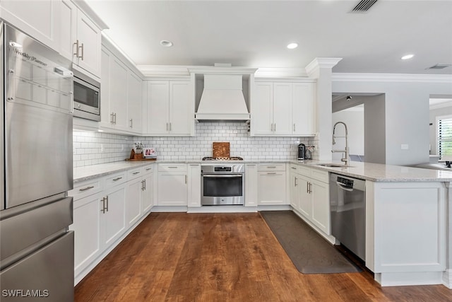 kitchen with dark wood-type flooring, appliances with stainless steel finishes, premium range hood, and white cabinets