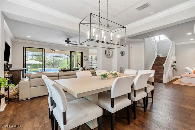 dining space featuring ornamental molding, dark wood-type flooring, and ceiling fan with notable chandelier