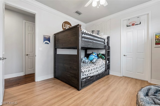 bedroom featuring crown molding, light hardwood / wood-style flooring, and ceiling fan