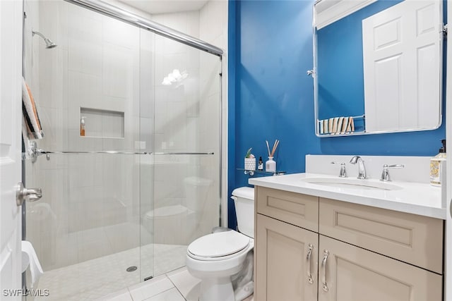 bathroom with a shower with door, vanity, toilet, and tile patterned flooring