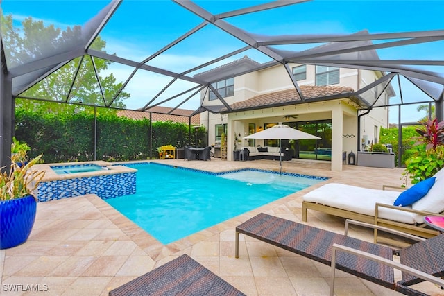 view of pool with outdoor lounge area, an in ground hot tub, a patio area, and glass enclosure