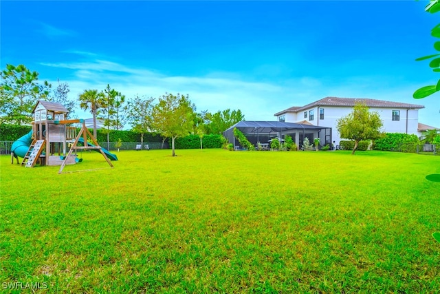 view of yard with a lanai and a playground