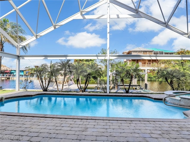 view of swimming pool featuring glass enclosure and a water view