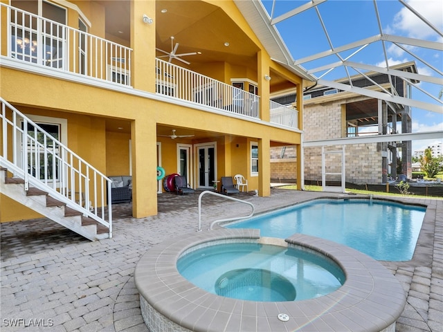 view of swimming pool with an in ground hot tub, french doors, a lanai, ceiling fan, and a patio area