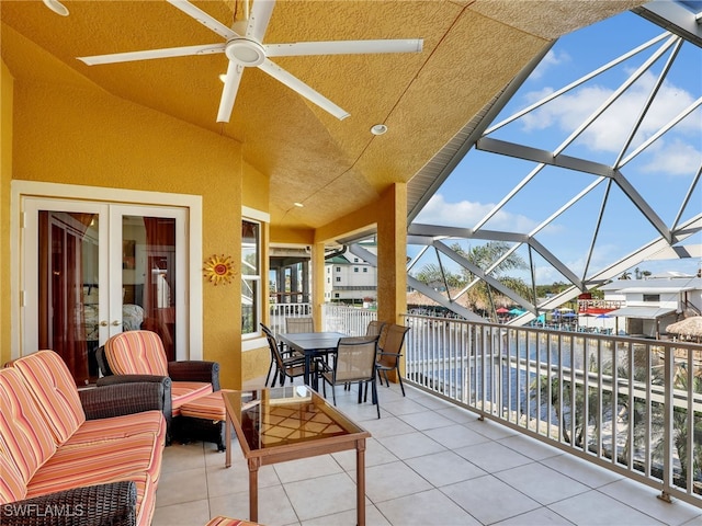 view of patio with ceiling fan and glass enclosure