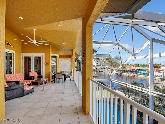 view of patio / terrace featuring french doors, a water view, a pool, and ceiling fan