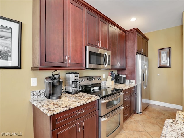 kitchen featuring light stone countertops, light tile patterned floors, and stainless steel appliances